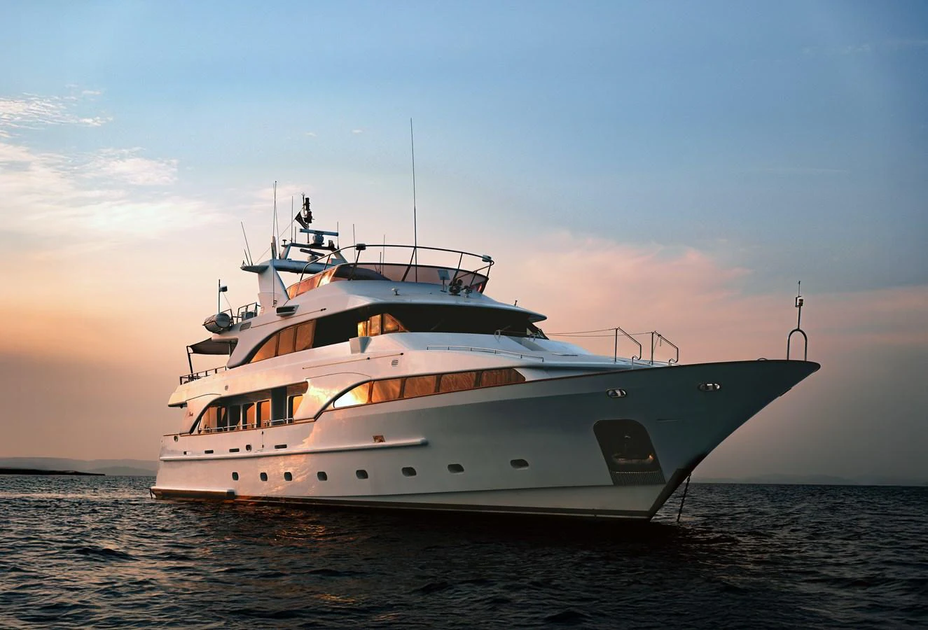 A luxurious yacht is gracefully cruising on calm waters at sunset. aboard FRIENDSHIP Yacht for Sale
