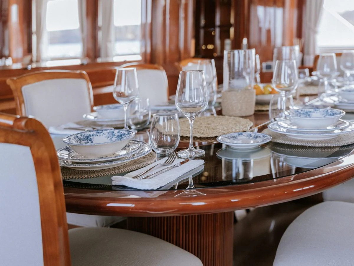 The yacht's dining area features an elegant table set with fine china and glassware, creating a sophisticated dining experience. aboard FRIENDSHIP Yacht for Sale