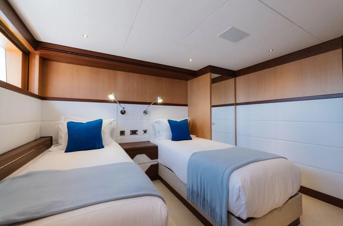 The guest stateroom features twin beds with plush bedding and elegant wood paneling. aboard GRAYCLIFFS Yacht for Sale