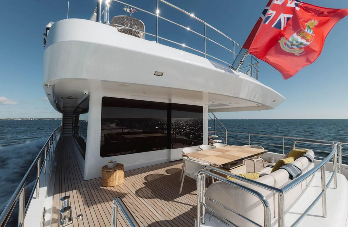 The aft deck features a spacious seating area with a dining table, perfect for enjoying meals with a view of the ocean. aboard GRAYCLIFFS Yacht for Sale