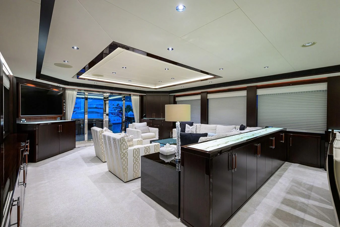 a room with a large window and a table with chairs and a tv aboard RENNEGADE Yacht for Sale