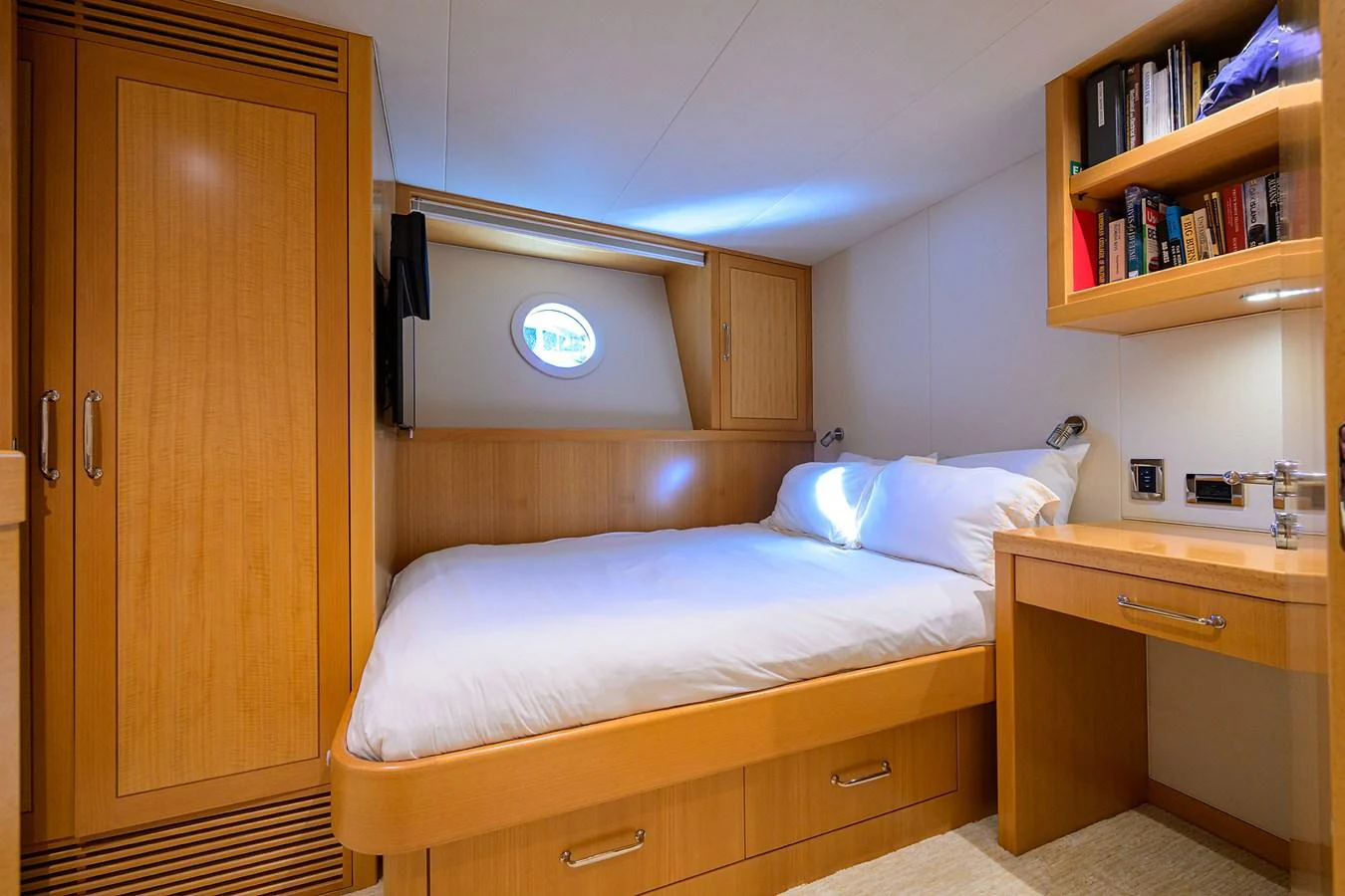a bedroom with a bed and a desk aboard RENNEGADE Yacht for Sale