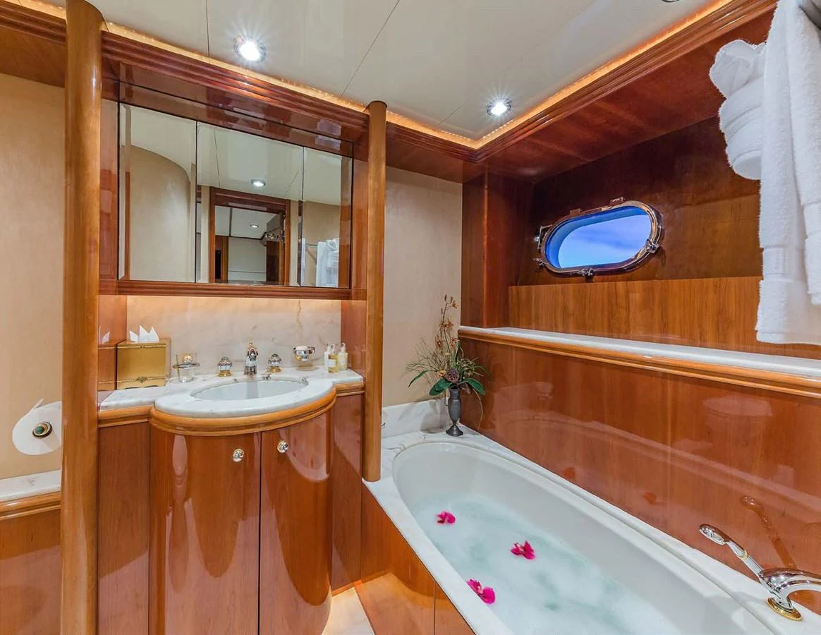 a bathroom with a tub sink and a mirror aboard AQUA Yacht for Sale