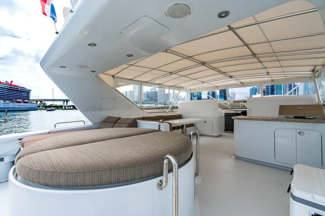 a room with a bed and a desk and a large window aboard AQUA Yacht for Sale
