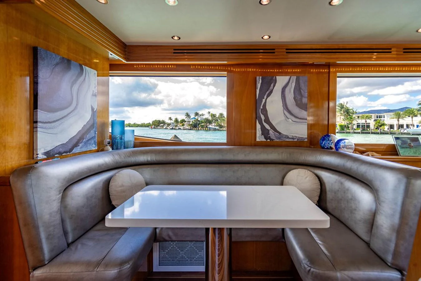 The yacht's dining area features a sleek table surrounded by plush seating with large windows offering scenic views. aboard WATER BORN Yacht for Sale