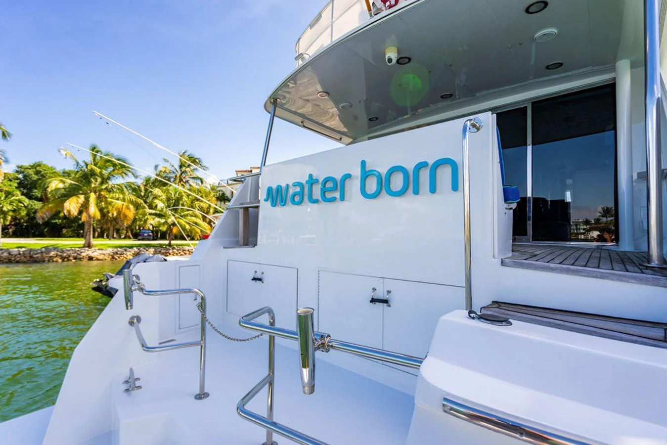 The aft deck of the yacht features a spacious area with steps leading down to the water, perfect for easy access and relaxation. aboard WATER BORN Yacht for Sale