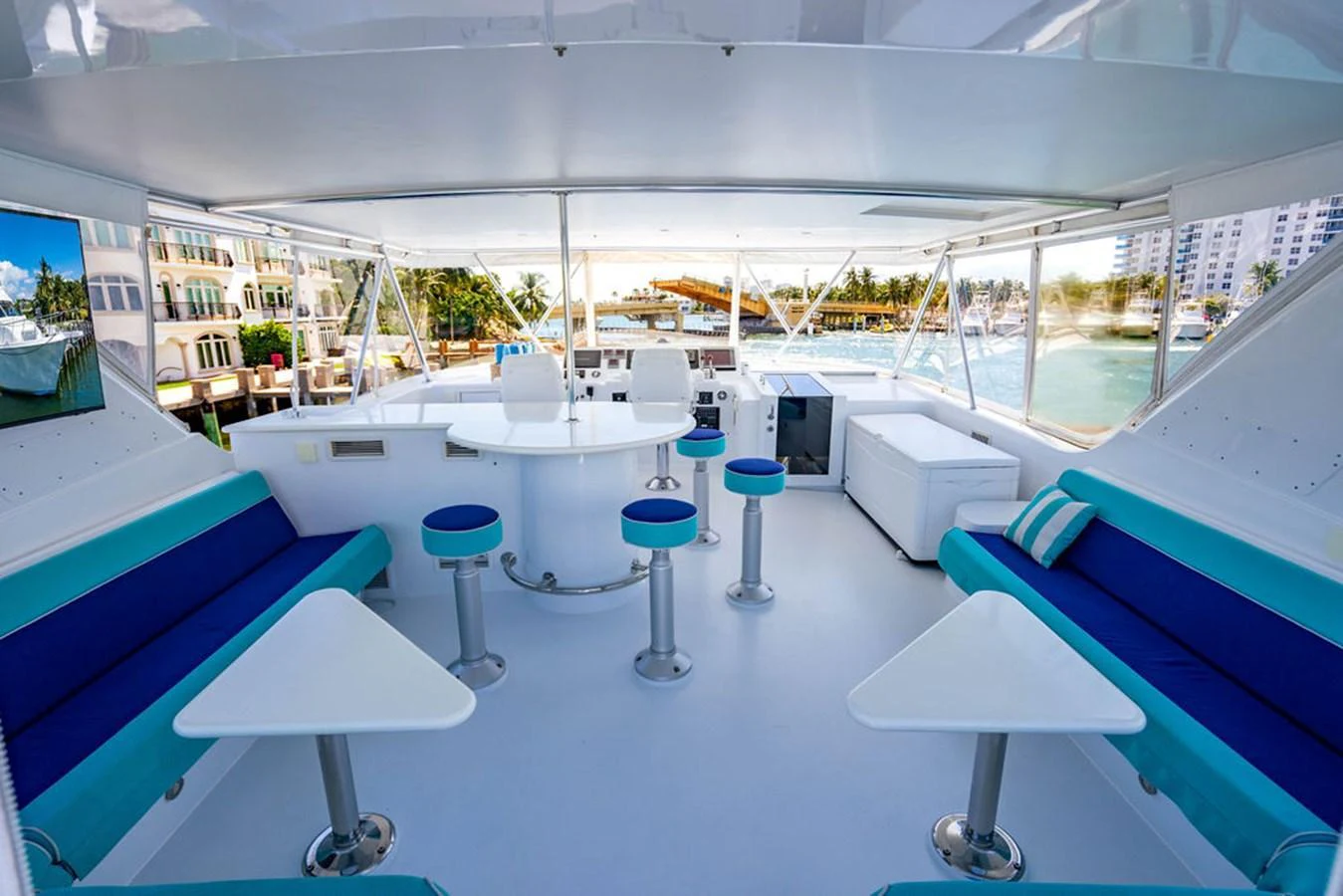 The spacious saloon features modern seating and a panoramic view of the marina. aboard WATER BORN Yacht for Sale