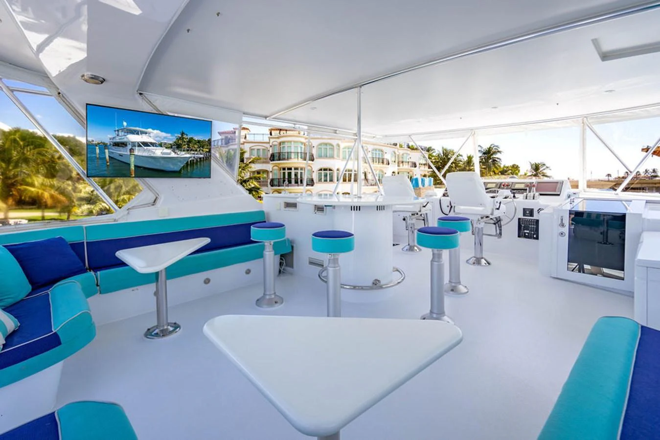 The flybridge offers a spacious and modern lounging area with ample seating and a large TV screen. aboard WATER BORN Yacht for Sale