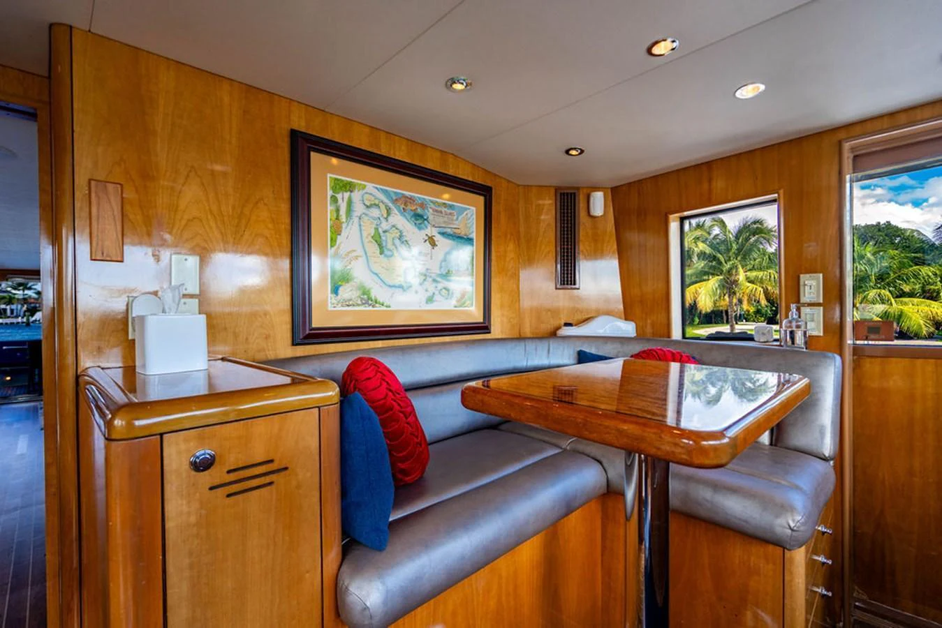 The yacht's dining area features a cozy booth with a polished wooden table and large windows offering scenic views. aboard WATER BORN Yacht for Sale