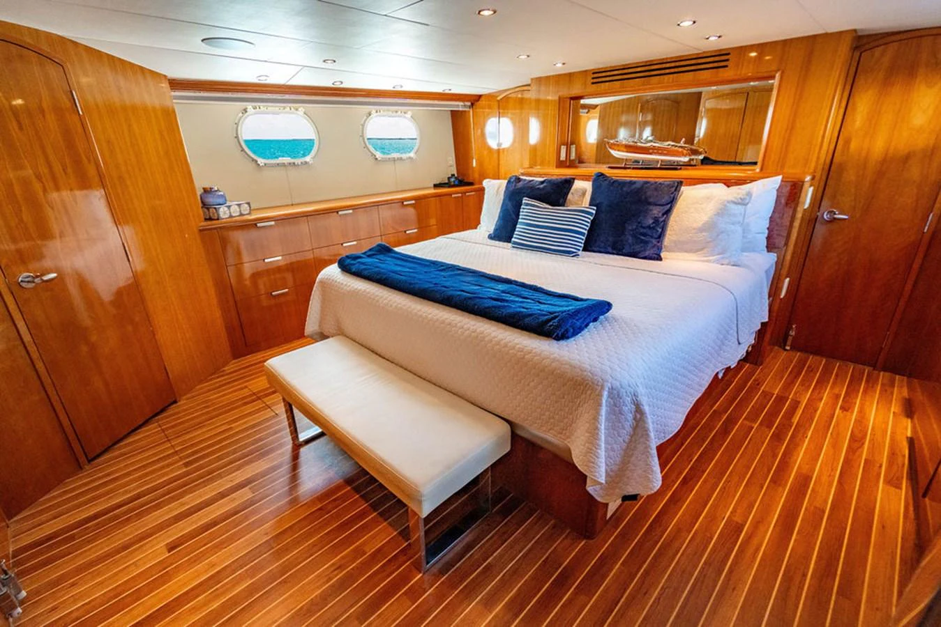The master stateroom features a luxurious bed with plush pillows and elegant wooden finishes. aboard WATER BORN Yacht for Sale