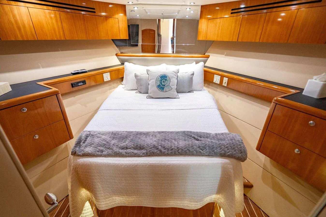 The stateroom features a cozy bed with elegant wooden cabinetry and soft lighting. aboard WATER BORN Yacht for Sale