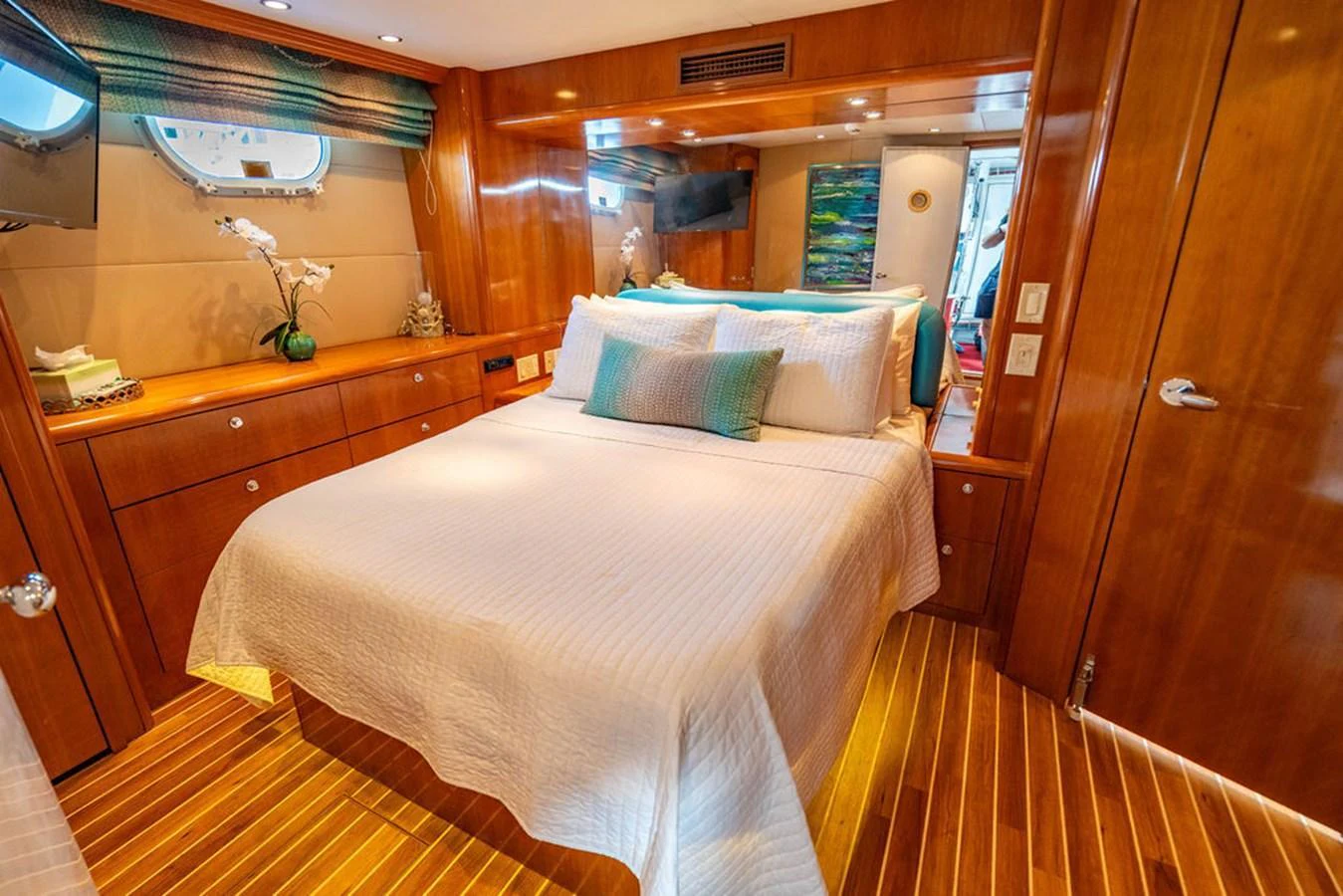 The stateroom features a cozy bed with elegant wooden furnishings and ample natural light. aboard WATER BORN Yacht for Sale