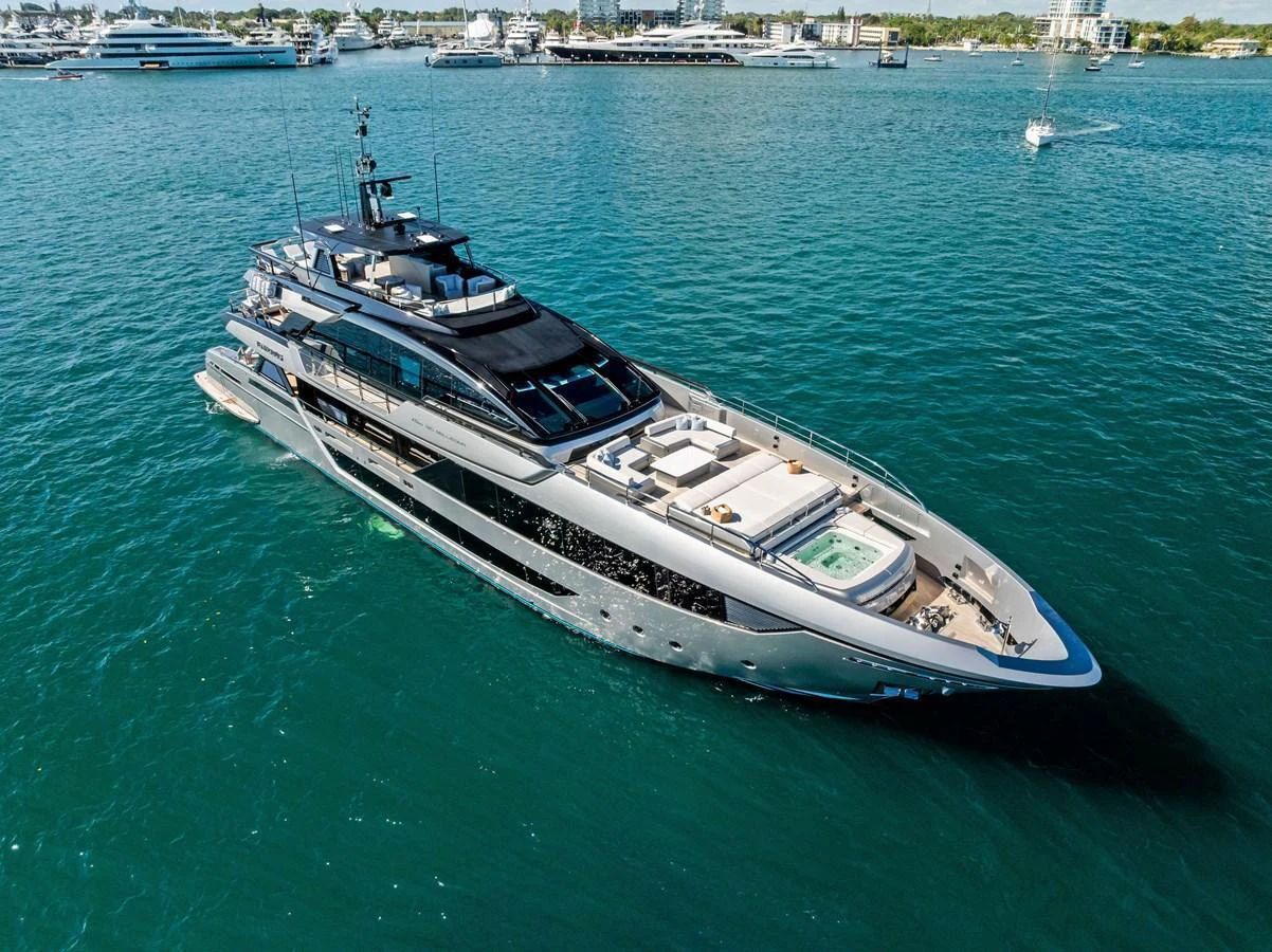 A sleek and modern yacht glides gracefully on the water, showcasing its luxurious design and spacious deck areas. aboard TENACIOUS Yacht for Sale