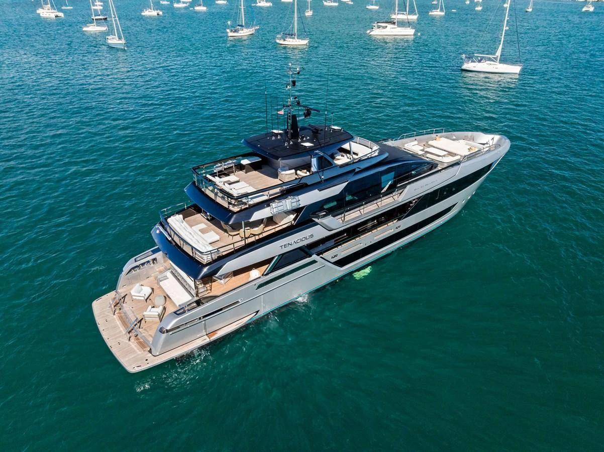 A luxurious yacht cruising on calm waters, surrounded by other boats. aboard TENACIOUS Yacht for Sale