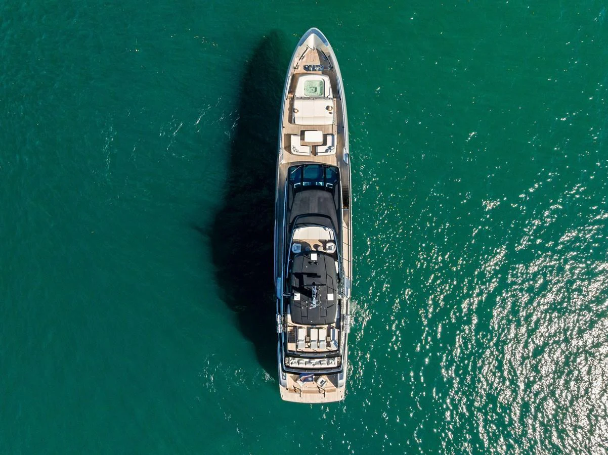 An aerial view of a sleek yacht cruising on clear blue waters. aboard TENACIOUS Yacht for Sale
