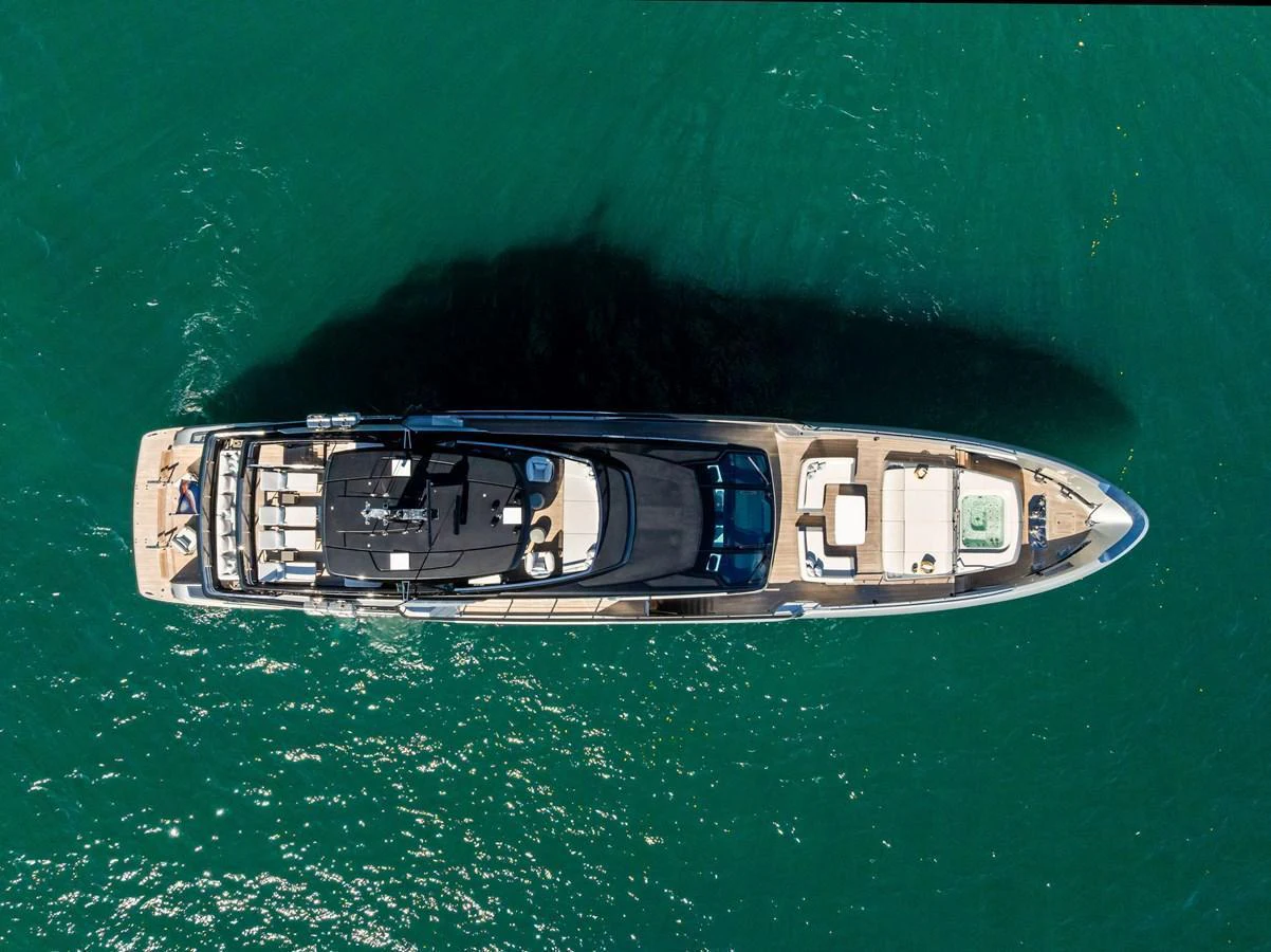 A stunning aerial view of a luxurious yacht cruising on clear blue waters. aboard TENACIOUS Yacht for Sale