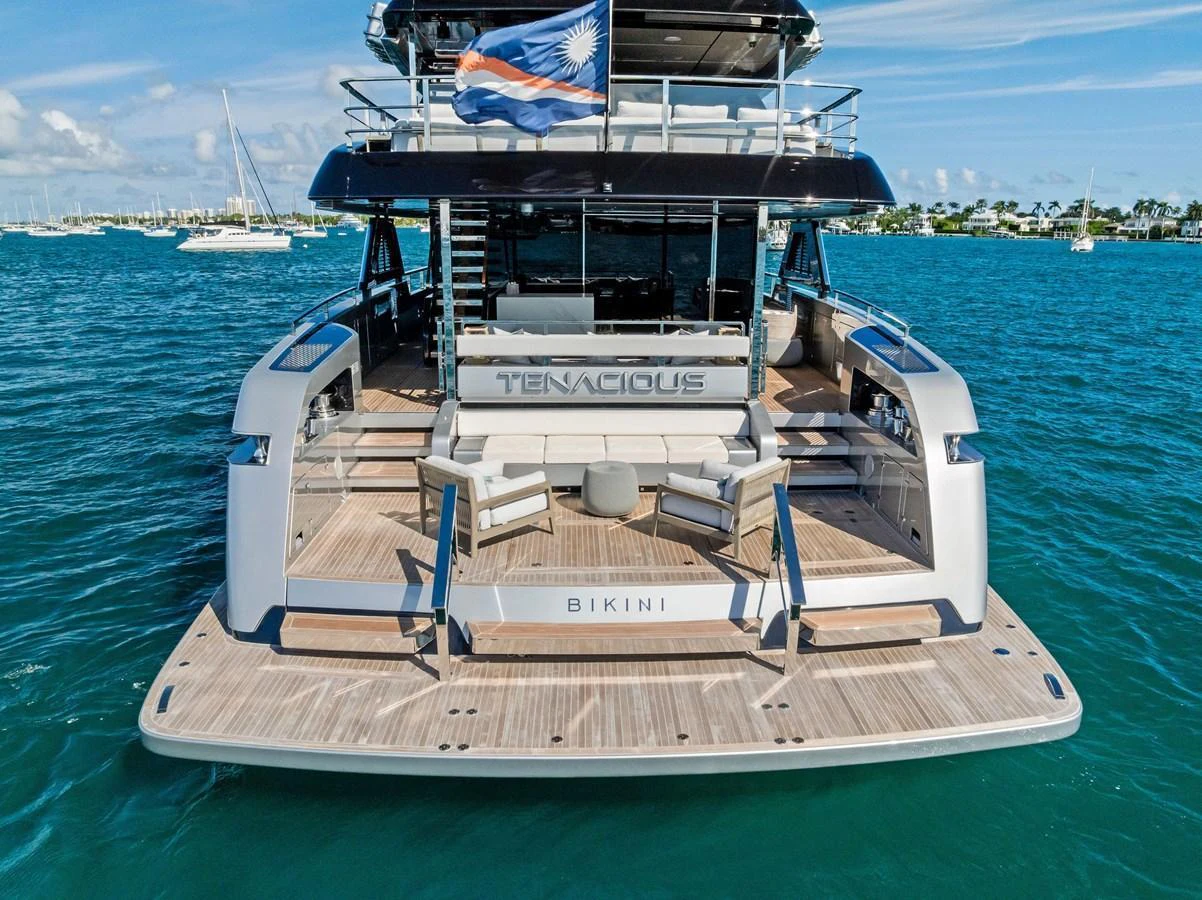 The yacht's aft deck features a spacious lounging area with a view of the surrounding waters. aboard TENACIOUS Yacht for Sale