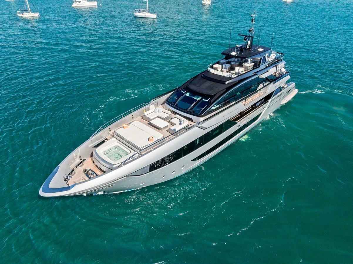 A sleek and modern yacht cruising on clear blue waters, showcasing its luxurious design and spacious decks. aboard TENACIOUS Yacht for Sale