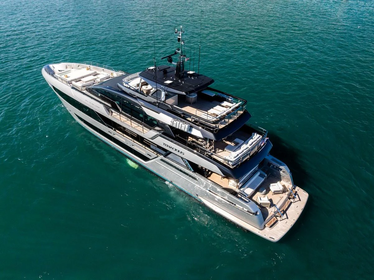 A sleek and modern yacht glides gracefully on the water, showcasing its luxurious design and spacious decks. aboard TENACIOUS Yacht for Sale