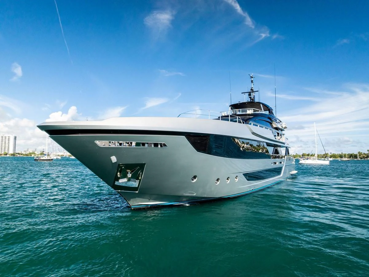 A sleek and modern yacht glides gracefully on the water under a clear blue sky. aboard TENACIOUS Yacht for Sale
