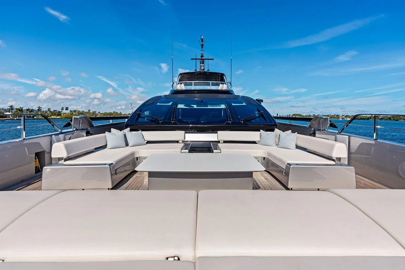 The aft deck features a spacious seating area with a central table, perfect for outdoor relaxation and dining. aboard TENACIOUS Yacht for Sale