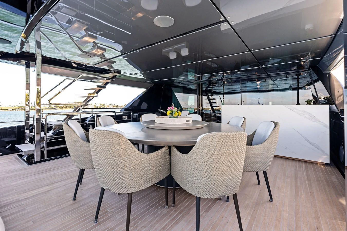 The yacht features a sleek and modern dining area with a round table and comfortable chairs, perfect for elegant meals on board. aboard TENACIOUS Yacht for Sale
