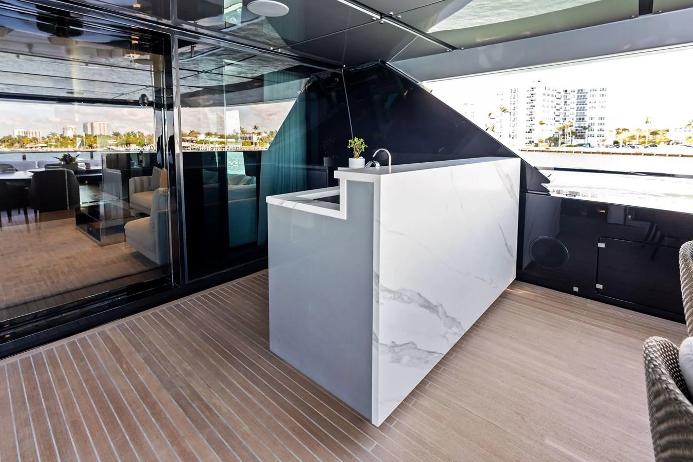 A sleek and modern bar area with a marble countertop and ample seating, perfect for entertaining guests. aboard TENACIOUS Yacht for Sale