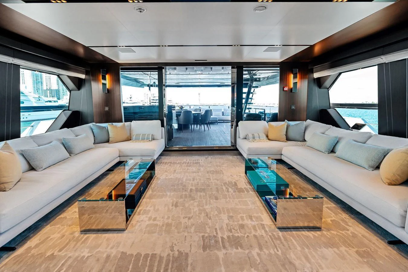 The spacious salon features luxurious seating and a modern, open layout with a view of the aft deck. aboard TENACIOUS Yacht for Sale