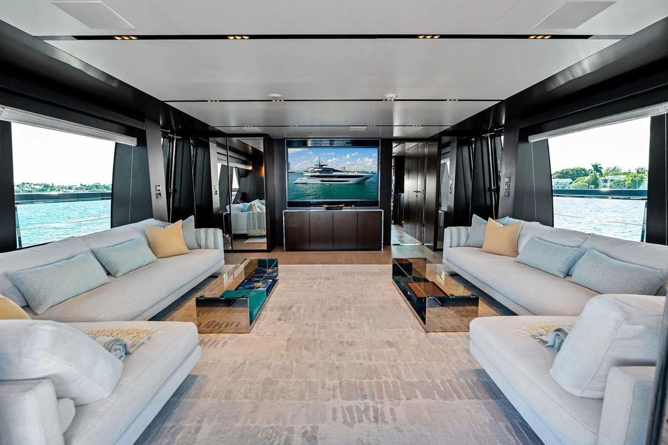 The salon boasts a spacious and luxurious seating area with large windows offering panoramic views. aboard TENACIOUS Yacht for Sale