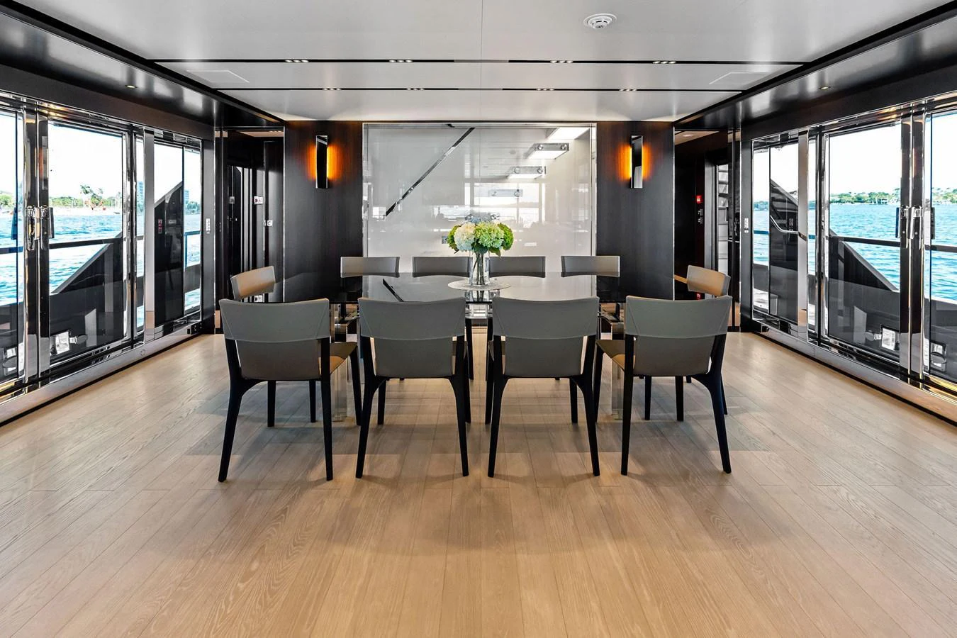The yacht's dining area features a sleek, modern design with ample natural light and a stunning view of the water. aboard TENACIOUS Yacht for Sale