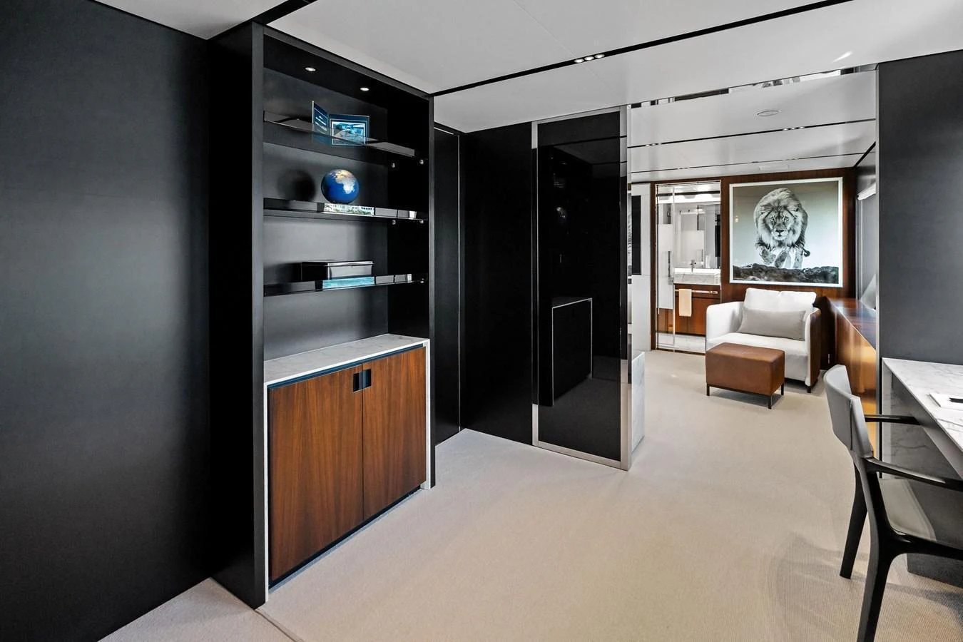 The yacht's interior features a modern, minimalist design with sleek black and wood accents. aboard TENACIOUS Yacht for Sale
