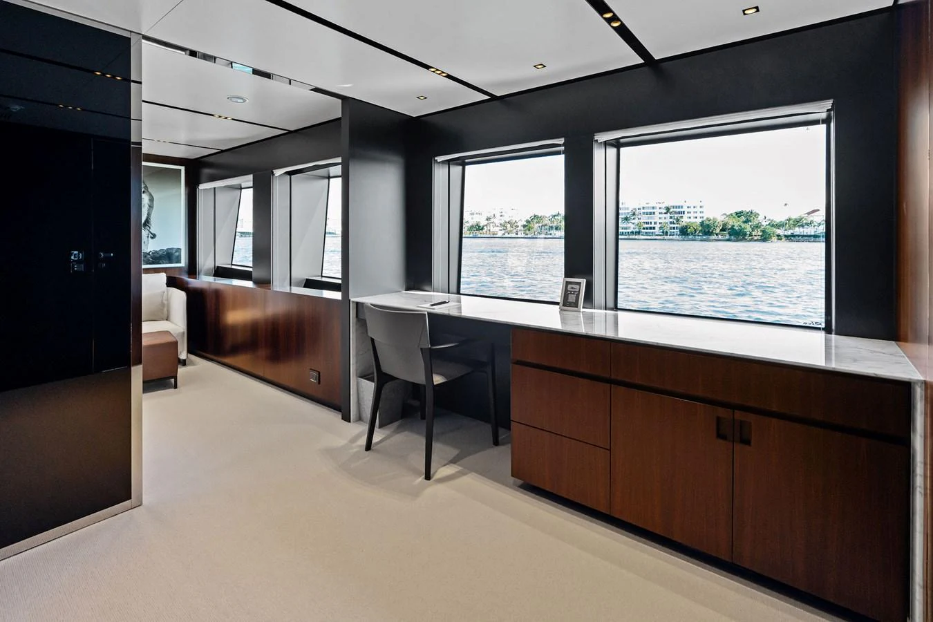 A sleek and modern office space with large windows offering stunning water views. aboard TENACIOUS Yacht for Sale