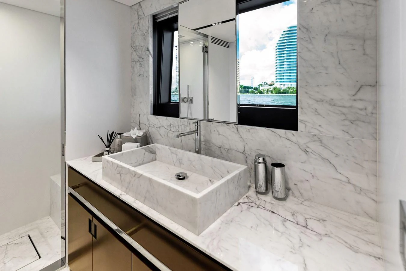 A luxurious yacht bathroom featuring a sleek marble countertop and modern fixtures. aboard TENACIOUS Yacht for Sale
