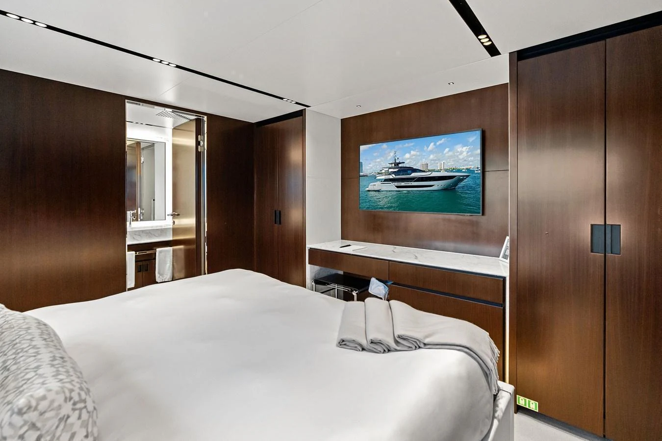 A luxurious stateroom featuring a large bed, modern decor, and a flat-screen TV. aboard TENACIOUS Yacht for Sale