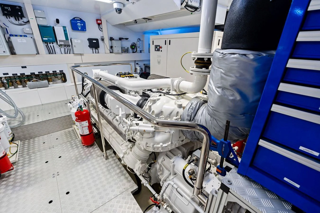 The image showcases a pristine and well-organized engine room with advanced machinery and safety equipment. aboard TENACIOUS Yacht for Sale