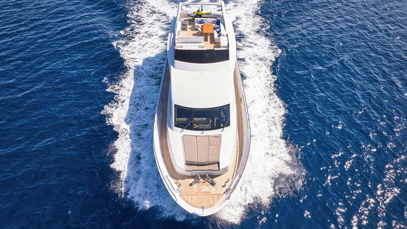 A sleek yacht cruises through the deep blue sea, showcasing its elegant design and spacious deck. aboard MILGAUSS Yacht for Sale