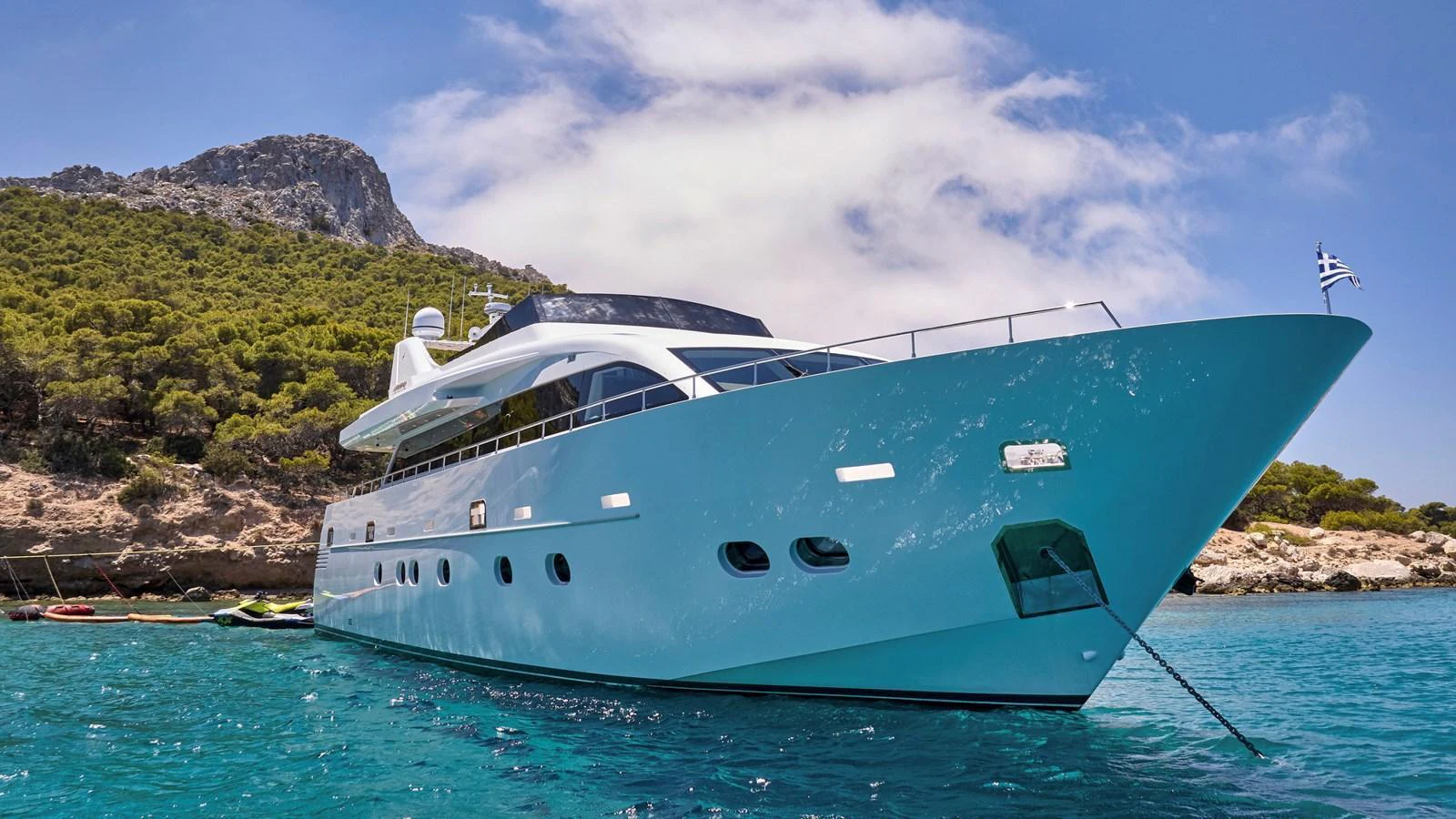 A sleek and modern yacht anchored in crystal-clear waters with a scenic backdrop. aboard MILGAUSS Yacht for Sale