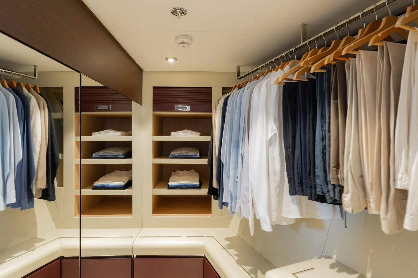 A well-organized yacht closet with hanging clothes and neatly folded items on shelves. aboard RENEGADE Yacht for Sale