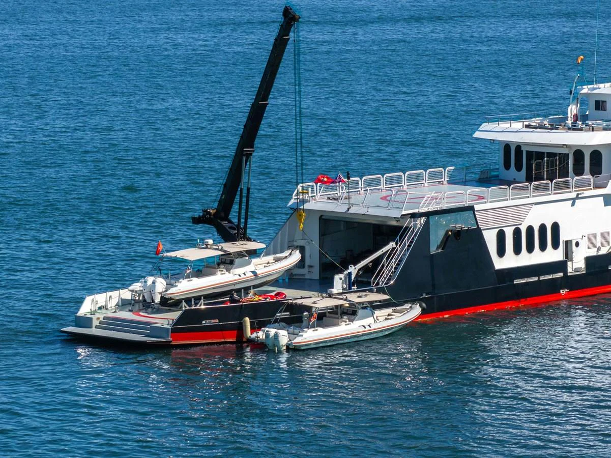 The yacht is docked on the water with several tenders alongside, showcasing its versatility and readiness for adventure. aboard GLOBAL Yacht for Sale