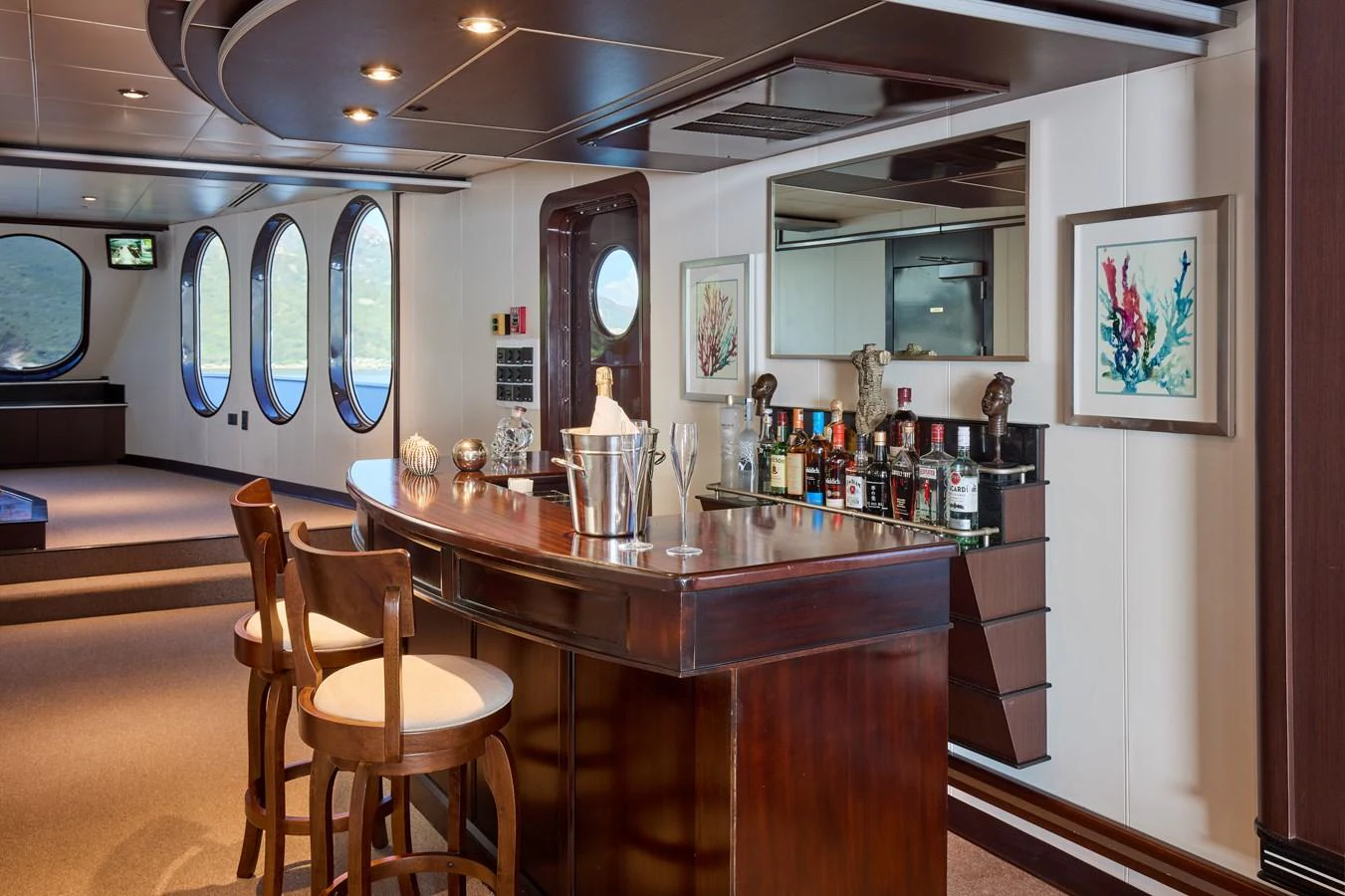The yacht's interior features a sophisticated bar area with elegant seating and a well-stocked counter. aboard GLOBAL Yacht for Sale
