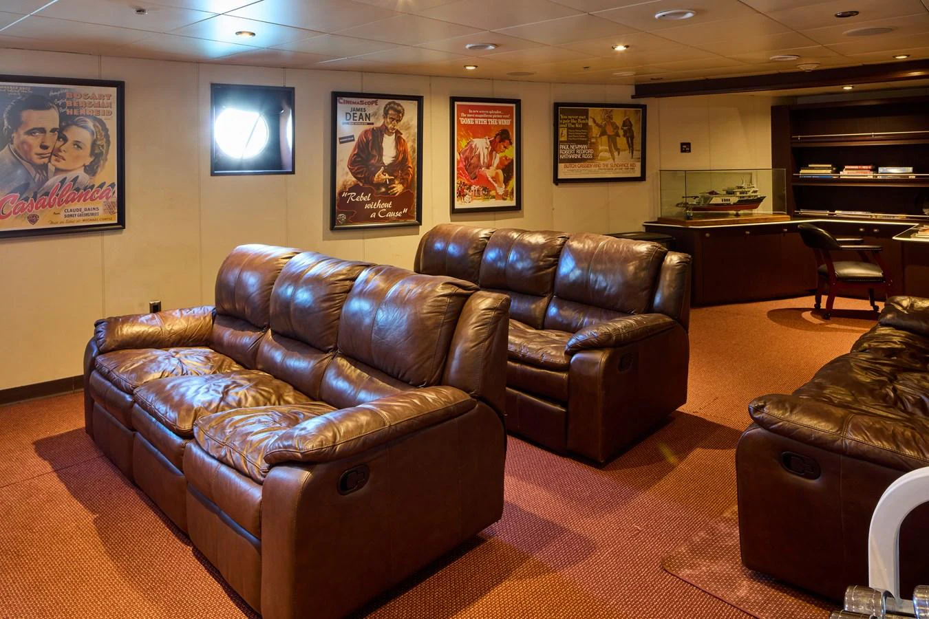 The yacht's lounge features plush leather seating and classic movie posters, creating a cozy and inviting atmosphere. aboard GLOBAL Yacht for Sale