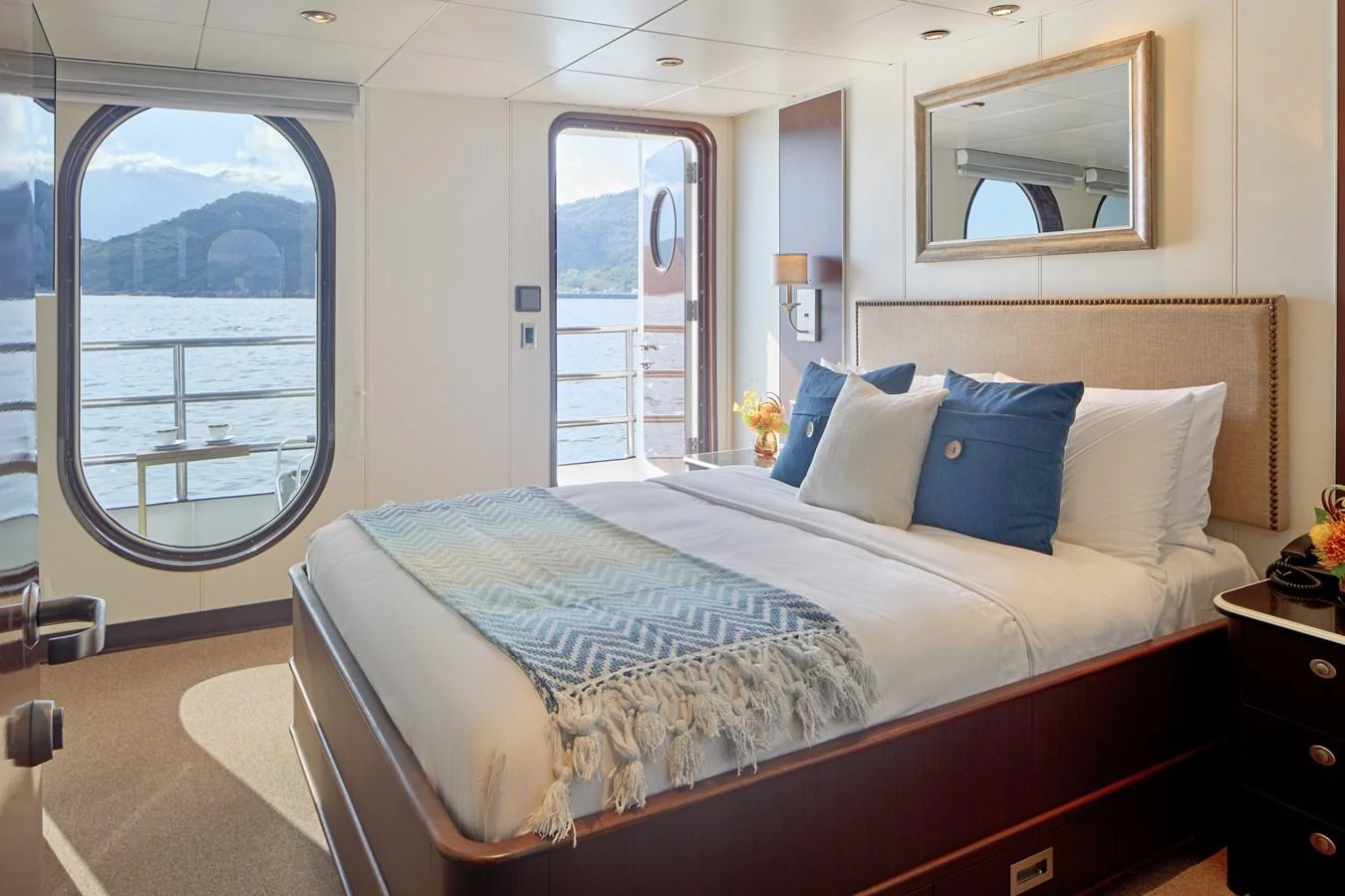 A luxurious stateroom with a large window and balcony access, offering stunning views of the sea. aboard GLOBAL Yacht for Sale