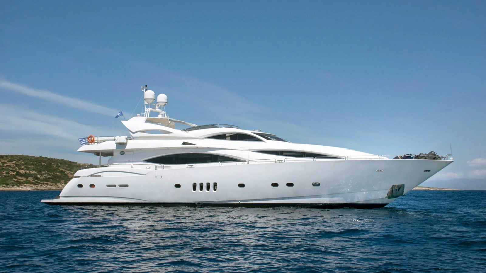 A sleek and modern yacht glides gracefully on calm waters against a backdrop of clear blue skies. aboard MI ALMA Yacht for Sale