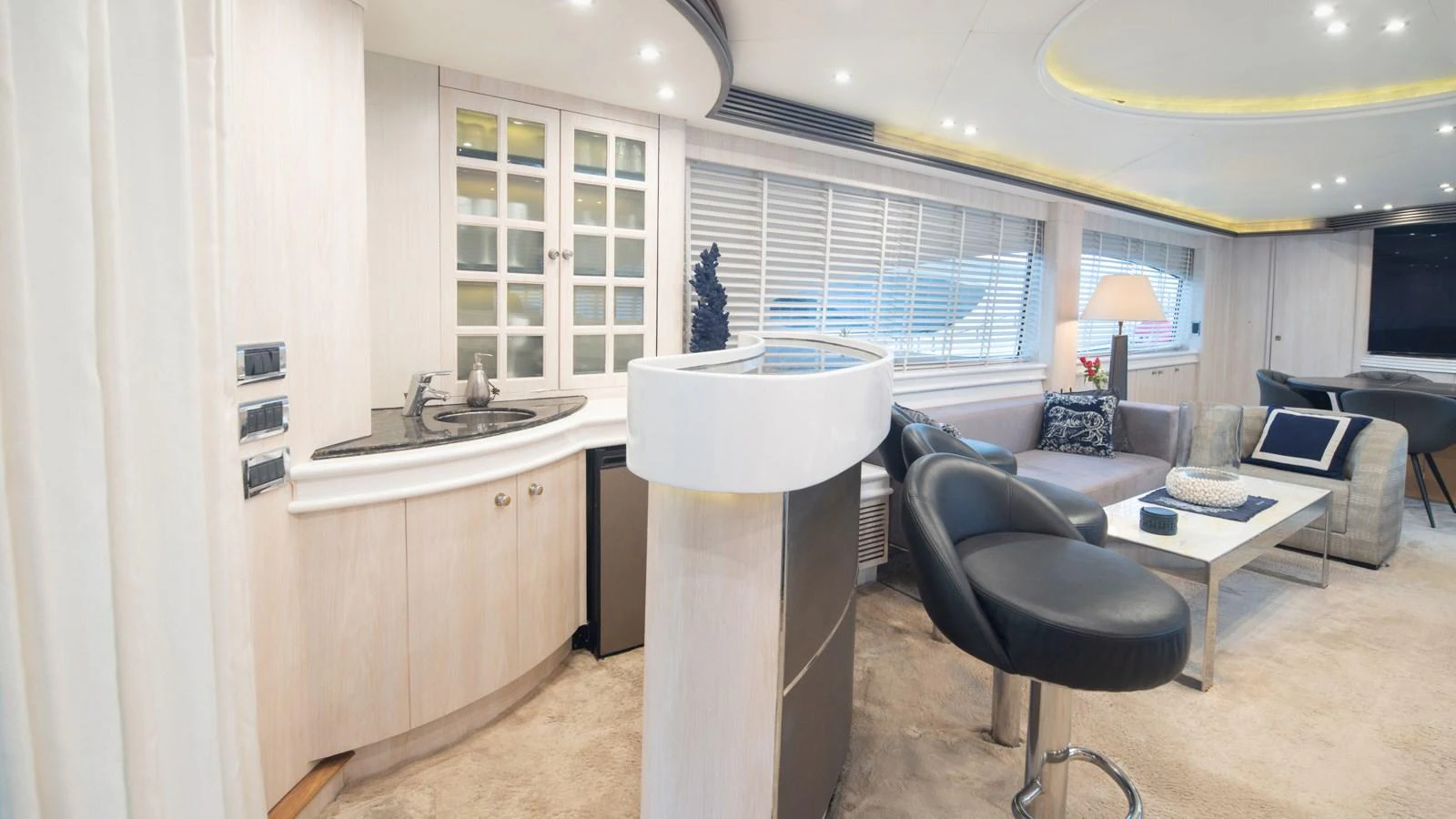 The salon features a modern and comfortable seating area with a stylish bar and ample natural light. aboard MI ALMA Yacht for Sale