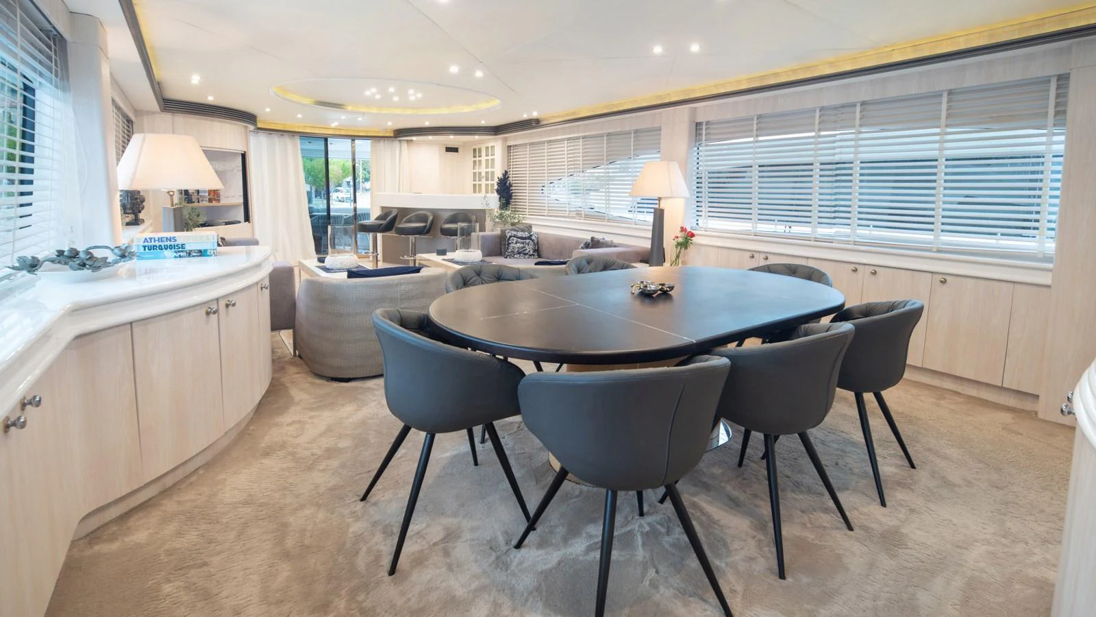 The yacht's dining area features a sleek, modern table surrounded by plush seating, creating an inviting space for meals and gatherings. aboard MI ALMA Yacht for Sale