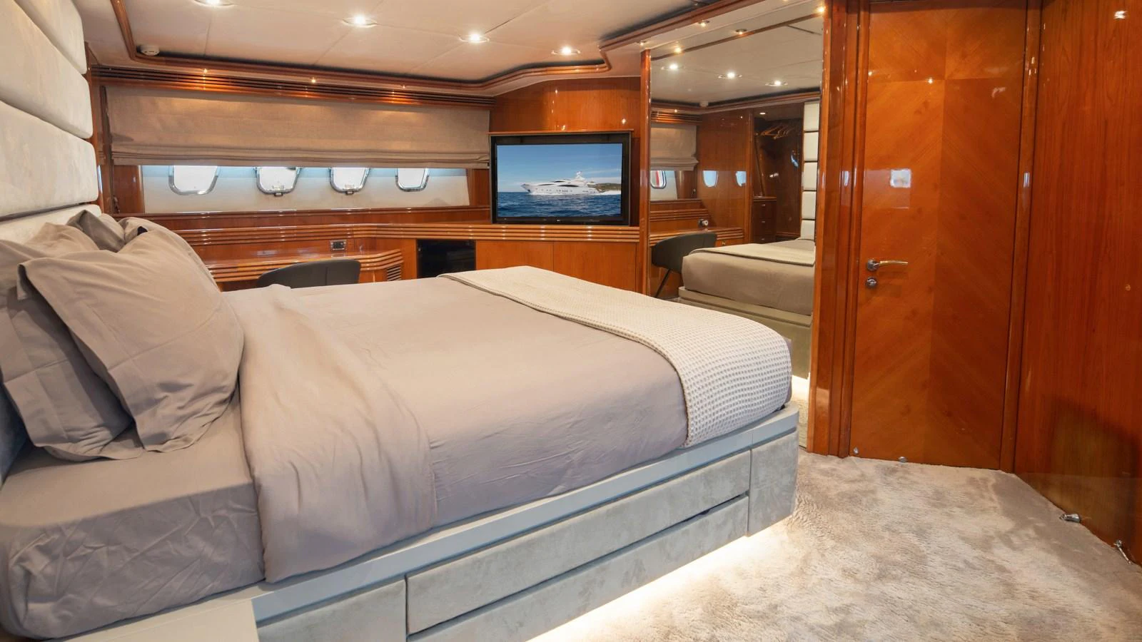 The master stateroom features a luxurious bed, rich wood paneling, and a flat-screen TV for ultimate comfort. aboard MI ALMA Yacht for Sale