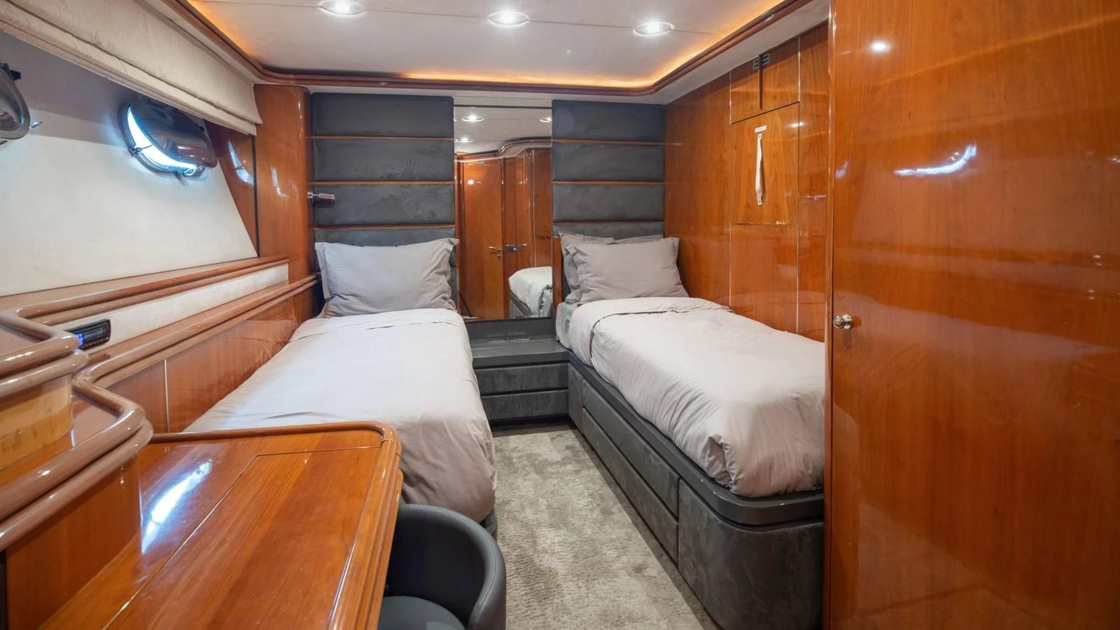 The twin stateroom features two single beds with luxurious bedding and warm wood finishes. aboard MI ALMA Yacht for Sale