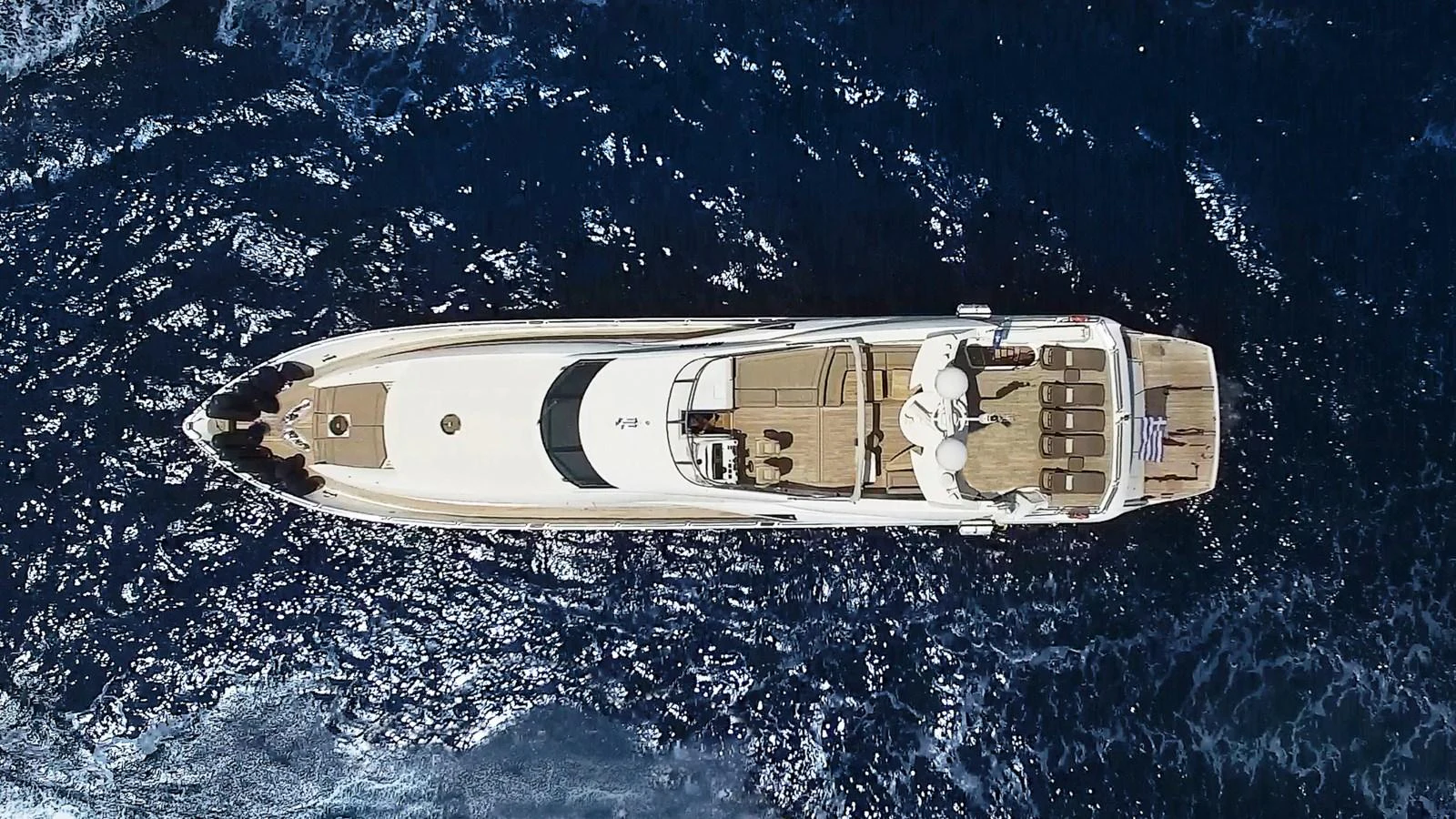 An aerial view of a sleek yacht cruising through deep blue waters. aboard MI ALMA Yacht for Sale