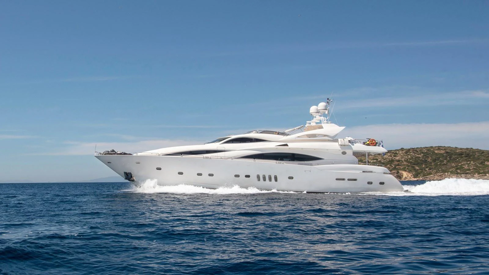 A sleek and modern yacht cruises through the open sea under a clear blue sky. aboard MI ALMA Yacht for Sale