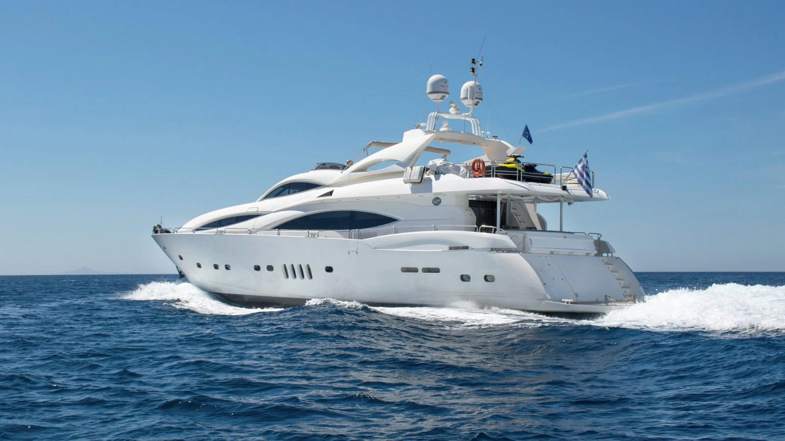 A sleek and modern yacht cruises through the open sea under a clear blue sky. aboard MI ALMA Yacht for Sale